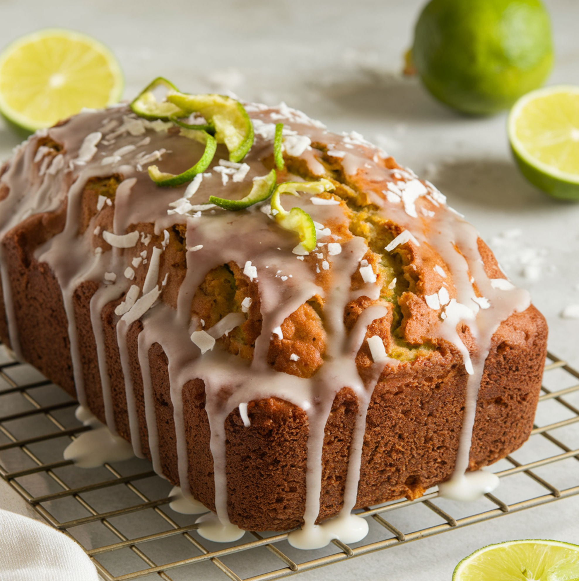 A freshly baked Coconut Lime Zucchini Loaf with a golden crust and lime glaze drizzle.