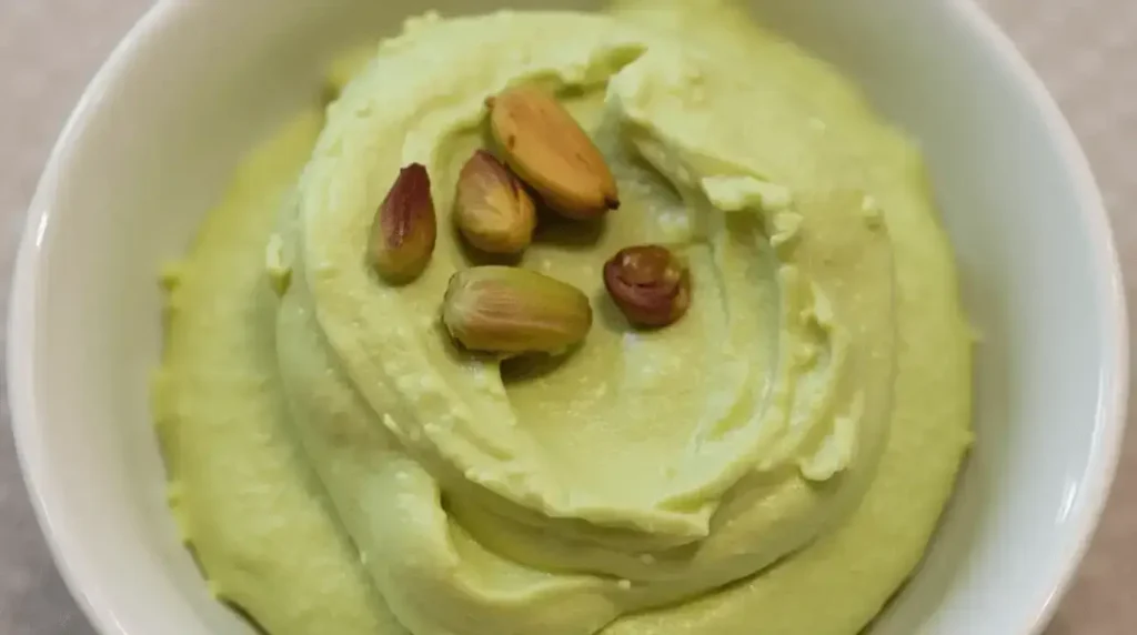 Pistachio Cream 3 A rich, velvety bowl of pistachio cream paired with pistachios and toast.